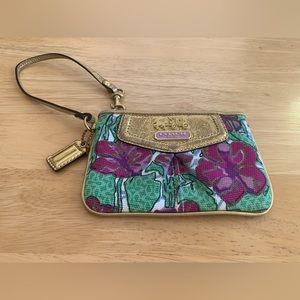 Coach small wristlet in floral fabric with gold leather trim and gold accents